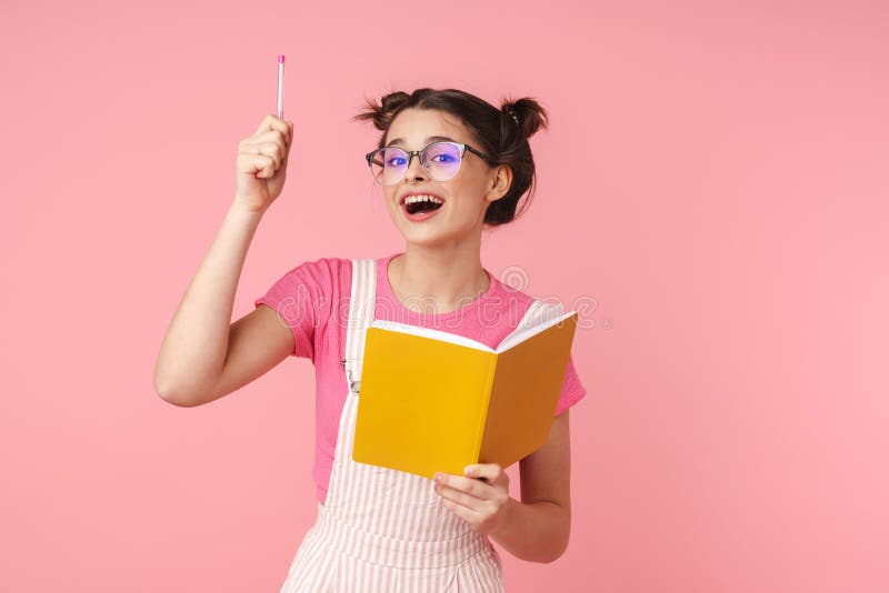 Photo of excited charming girl in eyeglasses writing in exercise book