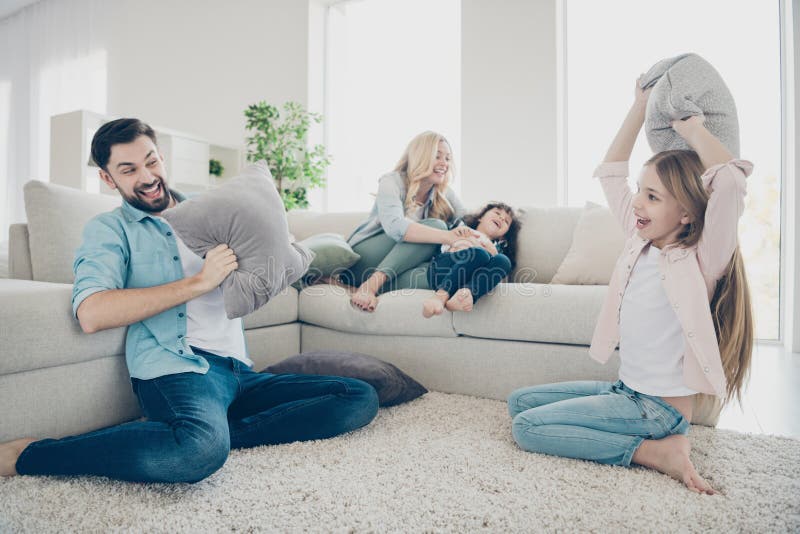 Photo of foster family four members spend leisure time rejoicing pillows fight giggle sit couch living room stock photo Photo of foster family four members spend leisure time rejoicing pillows fight giggle sit couch living room stock photo