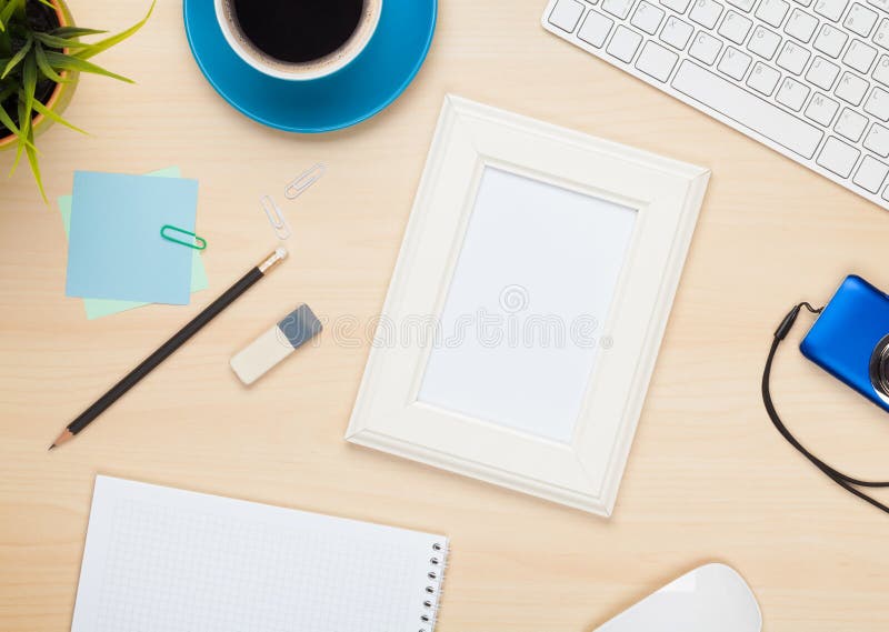 Photo Frame on Office Table with Notepad, Computer and Camera Stock