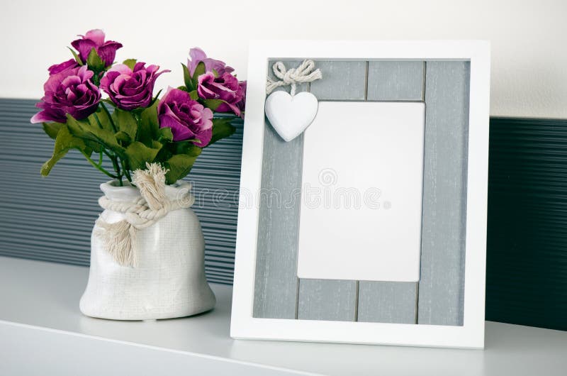 Photo frame stands on a shelf next to the flowers