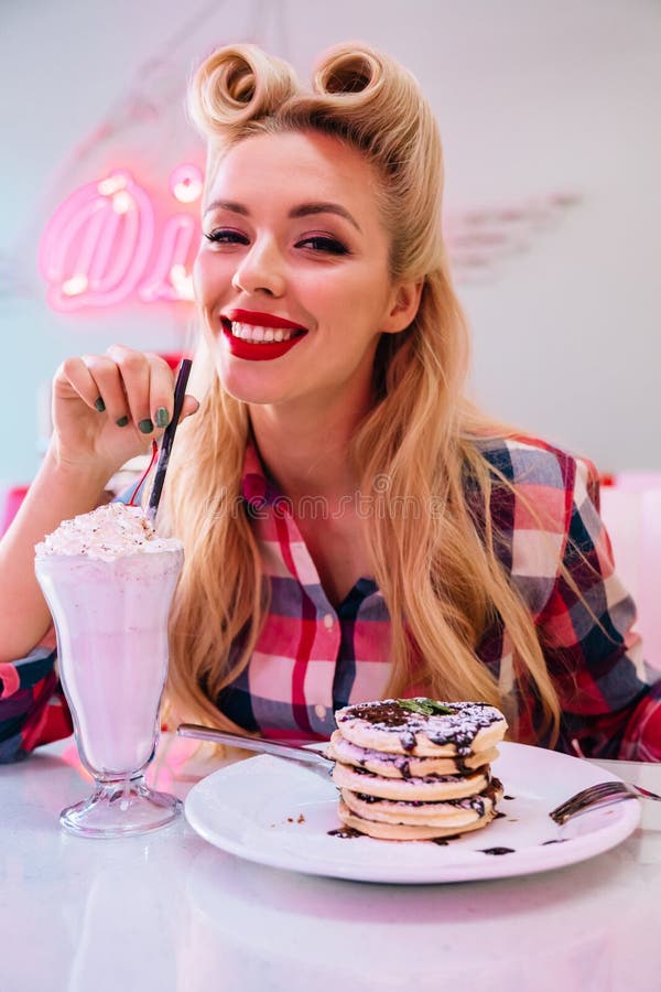 Photo of Gorgeous Cheerful Woman Eating Pancakes and Drinking Milkshake ...