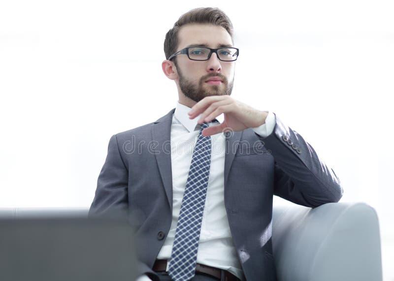 Young businessman looking to the camera wearing glasses