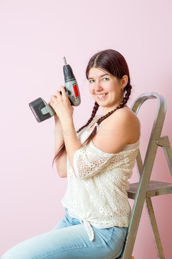 Photo of happy woman with drill near ladders stock photography Photo of happy woman with drill near ladders stock photography