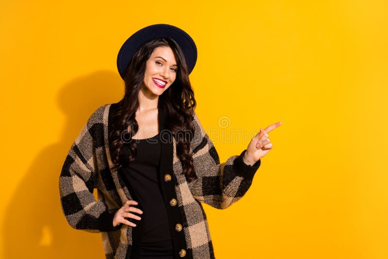 Photo of happy young woman point finger empty space promoter smile isolated on yellow color background