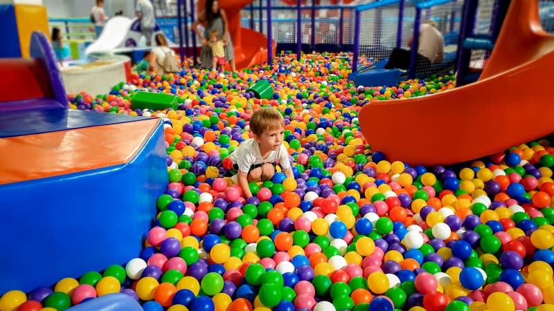 Photo of little boy playing in the pool full of colroful plastic balls. Toddler having fun on playground in shopping royalty free stock images Photo of little boy playing in the pool full of colroful plastic balls. Toddler having fun on playground in shopping royalty free stock images
