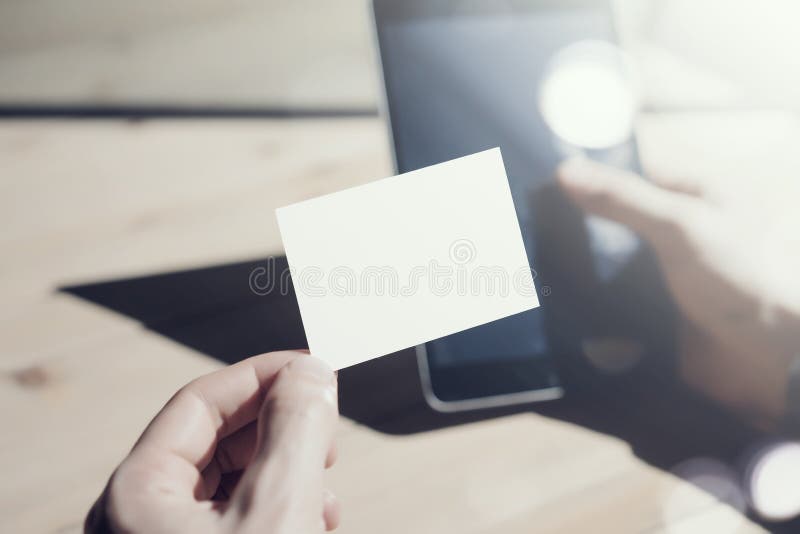 Photo Man Showing Blank White Business Card and Holding Hand Modern Smartphone Blurred Background. Mockup Ready for stock photography Photo Man Showing Blank White Business Card and Holding Hand Modern Smartphone Blurred Background. Mockup Ready for stock photography