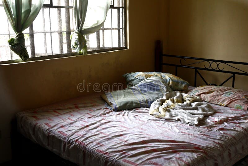 Messy bed beside bedroom window royalty free stock photos Messy bed beside bedroom window royalty free stock photos