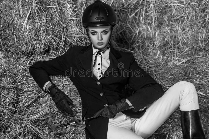 Photo moderne Jeune femme adulte dans l'équipement se reposant sur le foin photos libres de droits Photo moderne Jeune femme adulte dans l'équipement se reposant sur le foin photos libres de droits