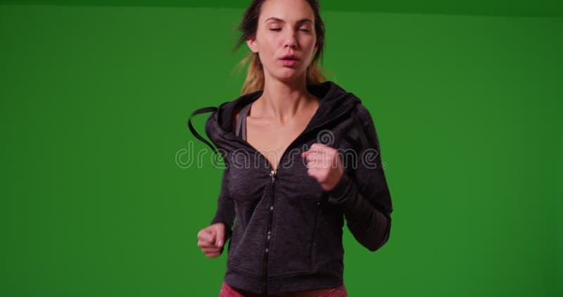 Photo médiane d'une jeune fille blanche qui court vers la caméra sur écran vert