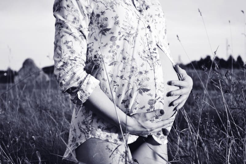 Photo noire et blanche de femme enceinte étreignant son ventre photographie stock libre de droits Photo noire et blanche de femme enceinte étreignant son ventre photographie stock libre de droits