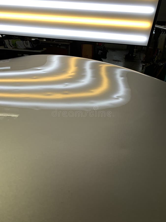 A photo of a paintless dent repair light showing hail dents. A photograph of a paintless dent repair hail light showing hail dents on a hood of a vehicle in the stock photos A photo of a paintless dent repair light showing hail dents. A photograph of a paintless dent repair hail light showing hail dents on a hood of a vehicle in the stock photos