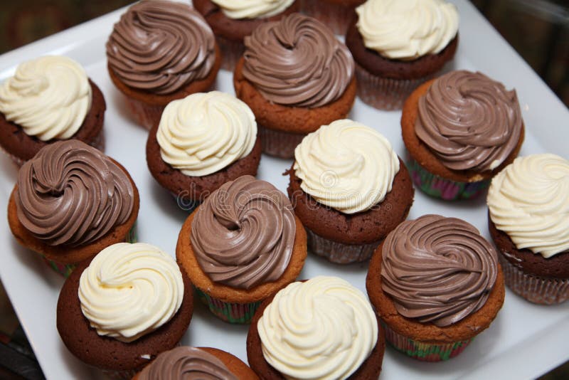 Photo porcelain dishes with 16 muffins with white chocolate spirals cream