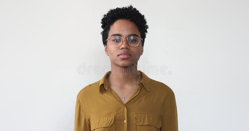 Photo portrait femme africaine heureuse pose sur fond studio gris banque de vidéos