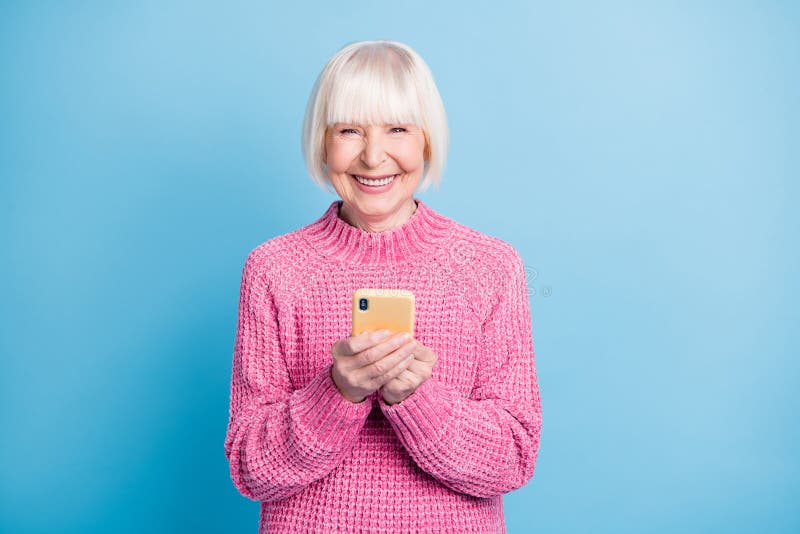 Photo Portrait Of Smiling Old Woman Holding Phone In Two Hands Isolated 