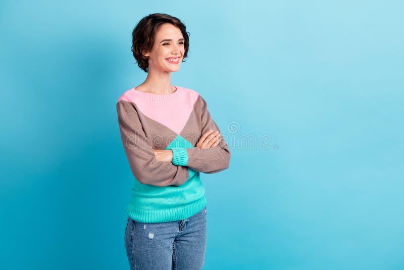 Photo portrait three fourths 3 4 angle of woman with crossed arms smiling isolated on pastel light blue colored