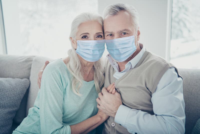 Photo of pretty elderly aged couple bonding leaning heads holding hands sitting on cozy sofa wearing gauze mask stay royalty free stock photo Photo of pretty elderly aged couple bonding leaning heads holding hands sitting on cozy sofa wearing gauze mask stay royalty free stock photo