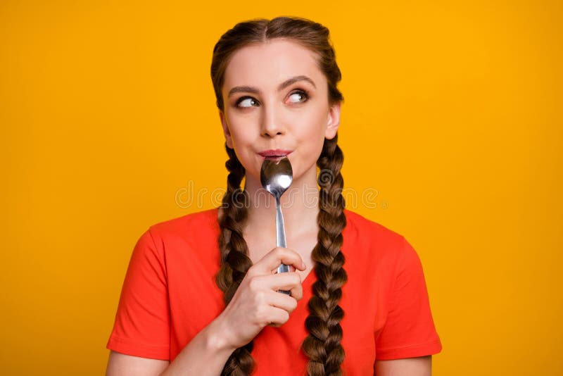 Photo of pretty teenager lady hold metal spoon in mouth desire dinner look dreamy empty space think of tasty food wear