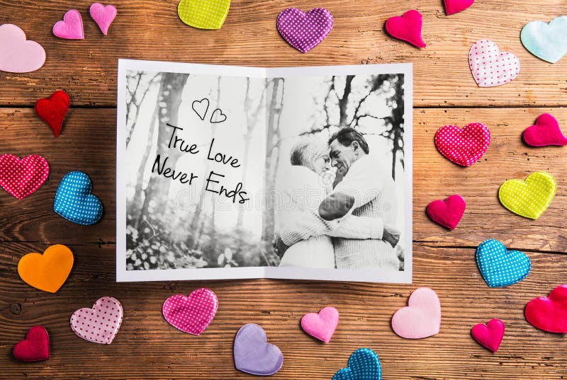 Photo of senior couple in love, colorful fabric hearts. Studio s