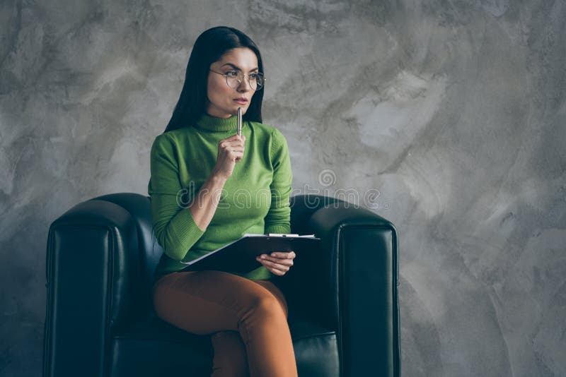 Photo of serious confident woman in orange pants touching chin with pen holding clipboard looking into empty space royalty free stock photos Photo of serious confident woman in orange pants touching chin with pen holding clipboard looking into empty space royalty free stock photos