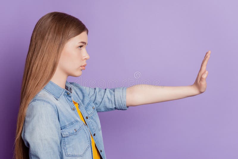 Photo of serious protester girl raise hand show stop sign look empty space side profile