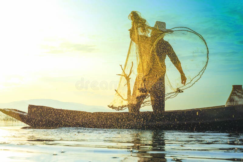 Photo shot of water spatter from fisherman while throwing fishing net on the lake. Silhouette of fisherman with fishing net in mo royalty free stock images Photo shot of water spatter from fisherman while throwing fishing net on the lake. Silhouette of fisherman with fishing net in mo royalty free stock images