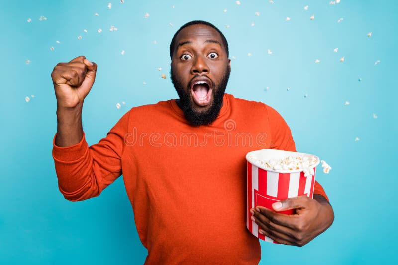 Photo of speechless stunned crazy handsome funny man shocked about plot twist of movie he watches holding bucket royalty free stock images
