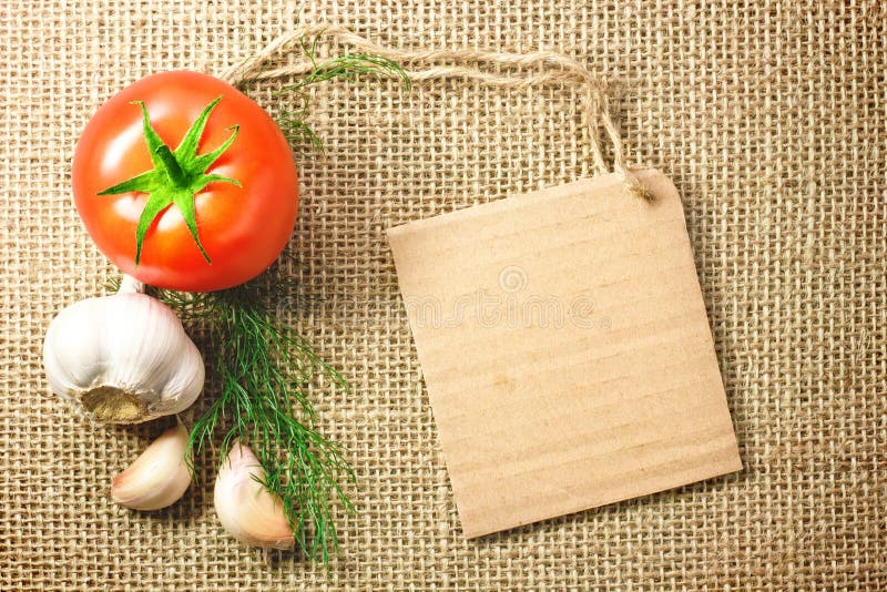 Tomato and garlic vegetables and price tag on sacking background