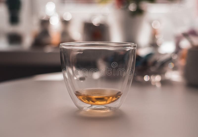 .transparent mug with green tea on the table against the background of the kitchen. Photo transparent mug with green tea on the table royalty free stock photo .transparent mug with green tea on the table against the background of the kitchen. Photo transparent mug with green tea on the table royalty free stock photo