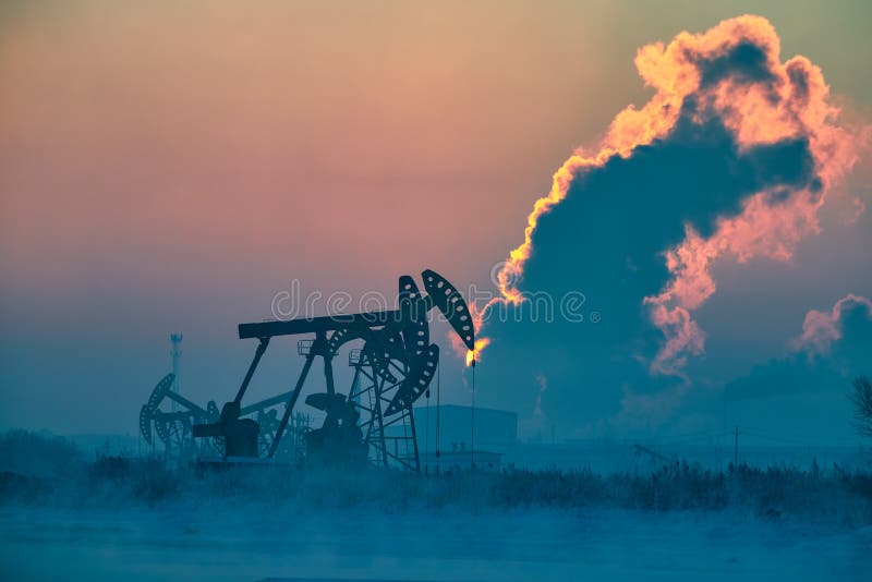 The pumping units lakeside sunrise in winter in Daqing oil fields