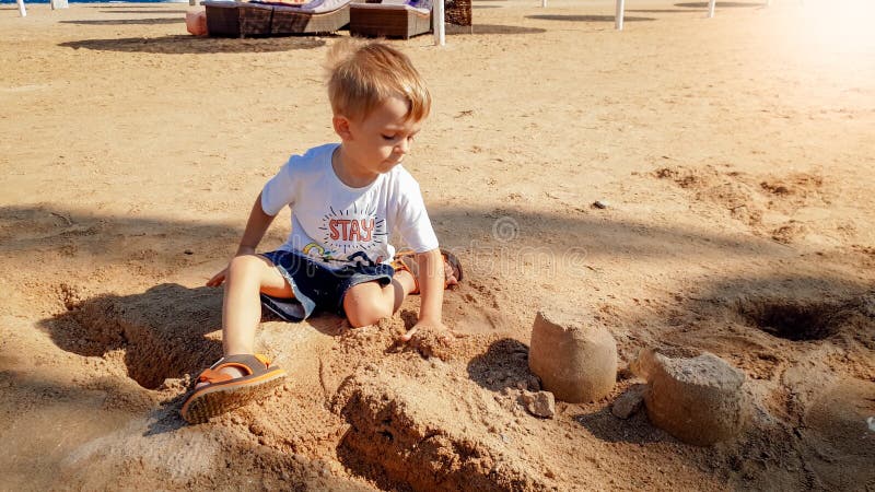 Image of 3 years old little toddler boy sitting on the sea beach and building castle from wet sand stock image Image of 3 years old little toddler boy sitting on the sea beach and building castle from wet sand stock image