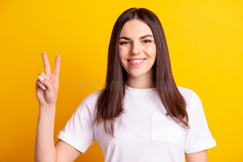 Photo of young cheerful girl good mood show fingers cool peace v-symbol isolated over yellow color background stock photos