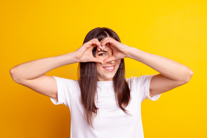 Photo of young cheerful girl show fingers heart symbol valentine day isolated over yellow color background royalty free stock image