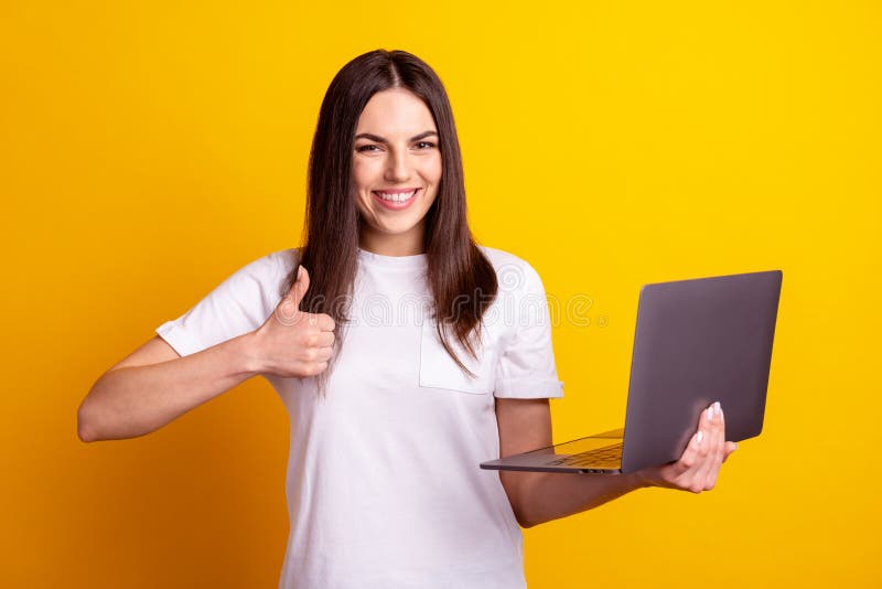 Photo of young cheerful lady show thumb-up advertising approve use laptop isolated over yellow color background stock images