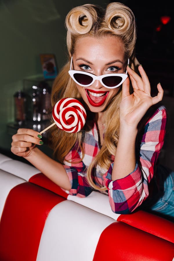 Photo of young cheerful woman holding lollipop and laughing