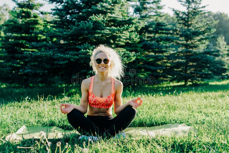Photo of young curly-haired sports woman practicing yoga on rug stock images Photo of young curly-haired sports woman practicing yoga on rug stock images