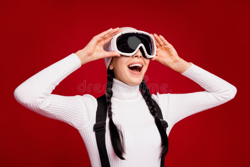 Photo of young happy positive good mood girl look in copyspace wear goggles snowboarding isolated on red color