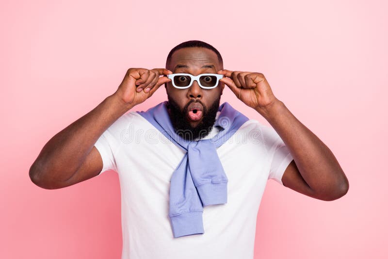 Photo of young impressed young man watching 3d movie can't believe his eyes isolated on pink color background stock images