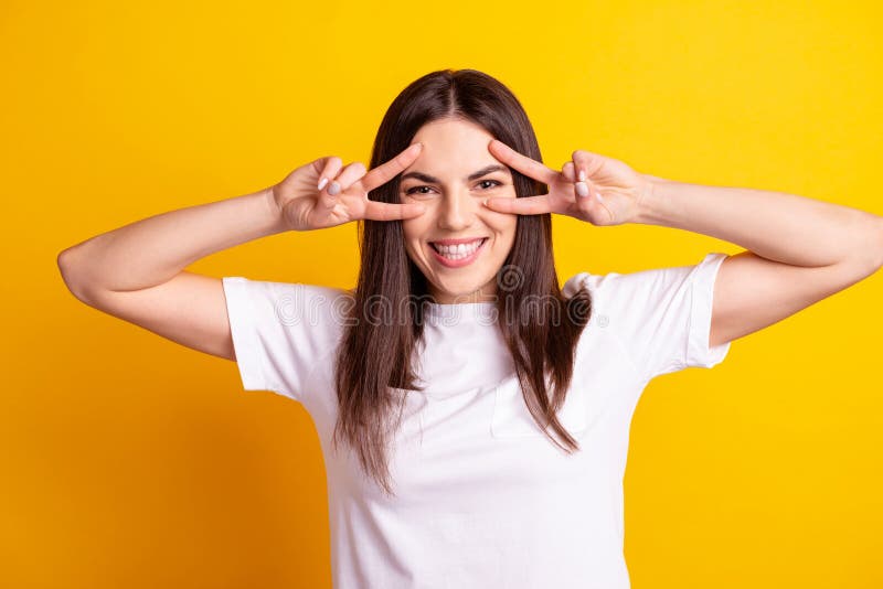 Photo of young lovely lady good mood show peace v-symbol wear casual outfit isolated over yellow color background royalty free stock image