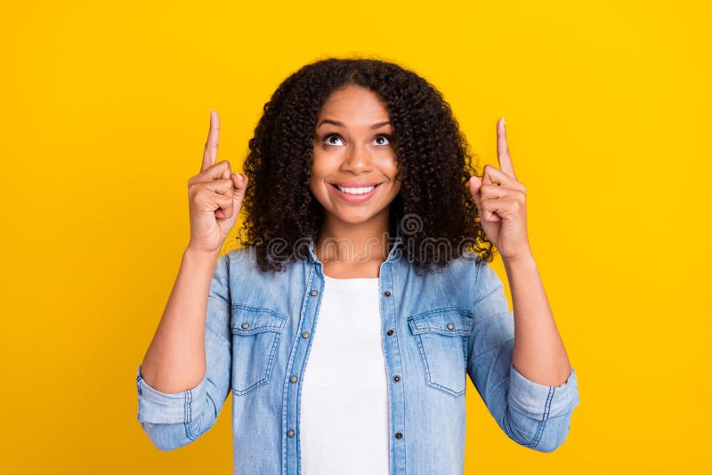 Photo of young positive dark skin woman point finger up empty space news sale isolated on yellow color background
