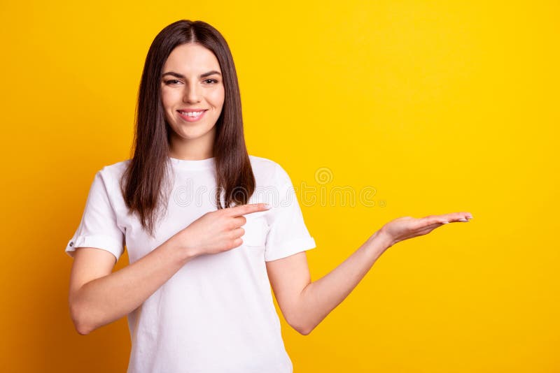 Photo of young pretty girl promoter indicate finger product offer advertise isolated over yellow color background royalty free stock images