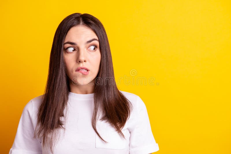 Photo of young pretty lady bite lips wondered look empty space scared worried look empty space isolated over yellow royalty free stock photo