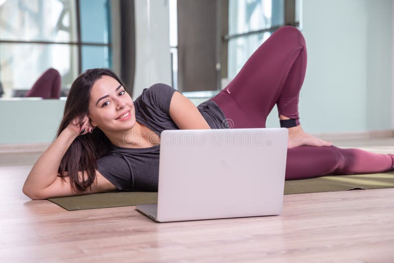 Photo of Young Woman Practicing Yoga with Laptop Indoor. Beautiful Girl ...