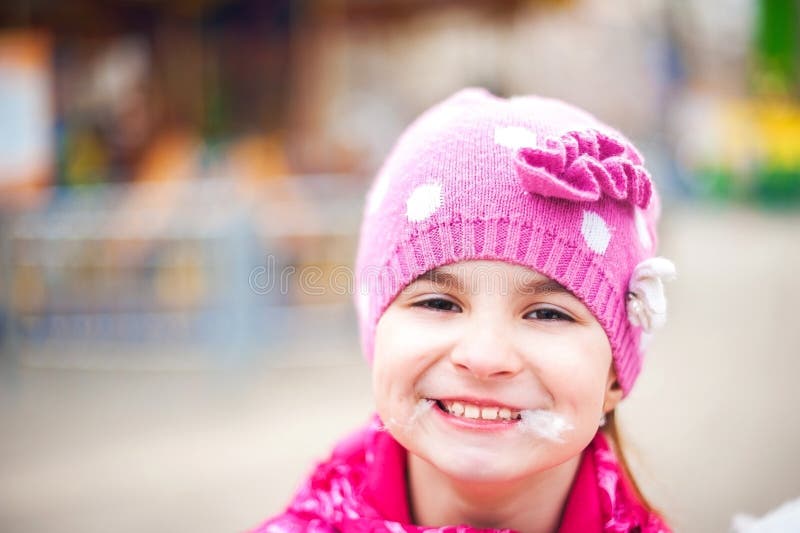 A photograph of a child`s rest on nature in the spring. A child girl in a bright pink jacket is eating sweet cotton wool against t royalty free stock image A photograph of a child`s rest on nature in the spring. A child girl in a bright pink jacket is eating sweet cotton wool against t royalty free stock image
