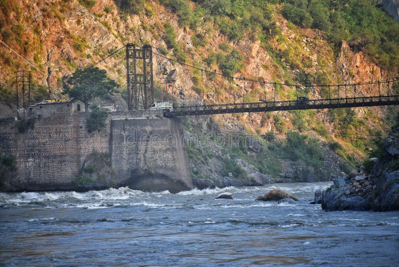 A photograph of a iron and wooden bridge over a river with mountain at background hitting by sunrays early in the morning royalty free stock photos A photograph of a iron and wooden bridge over a river with mountain at background hitting by sunrays early in the morning royalty free stock photos