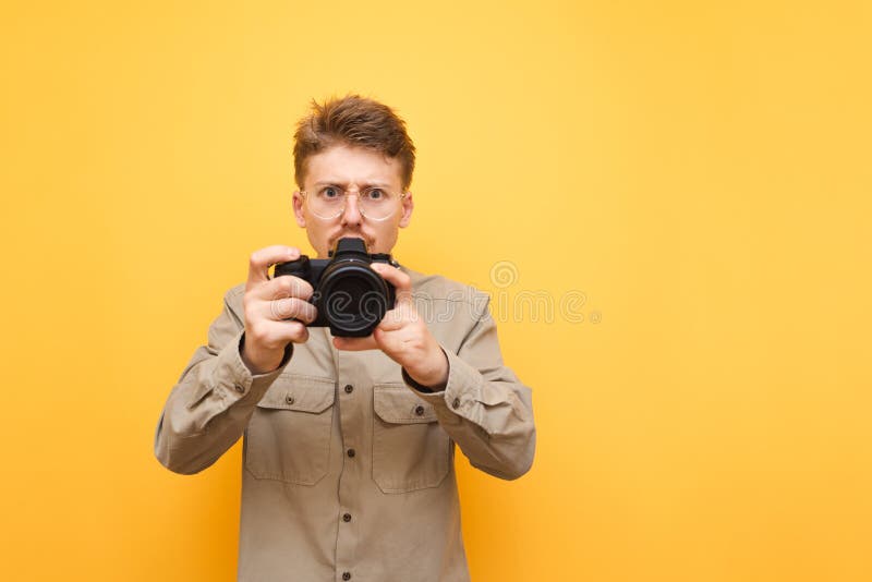 Photographe Drôle Avec La Position Grave De Visage Sur Le Fond