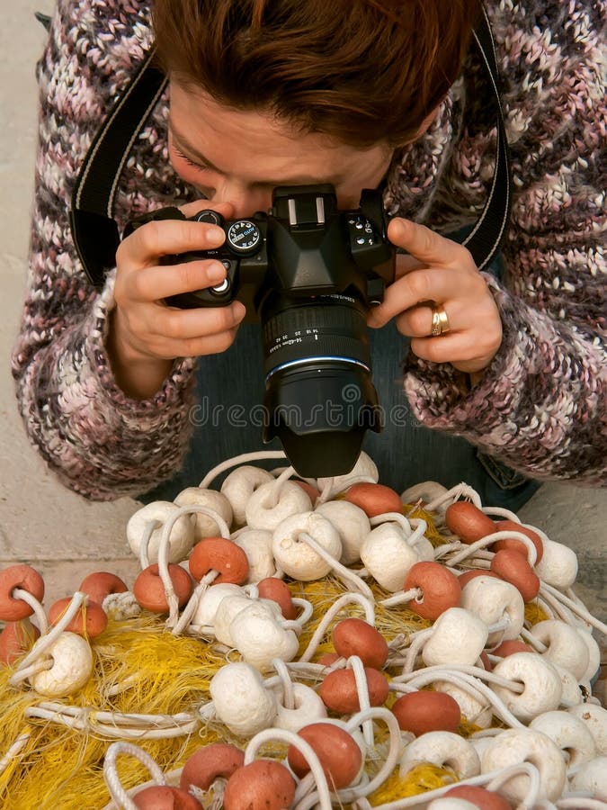 De una mujer fotógrafo cual profundamente concentrado fotografías afuera limpio.