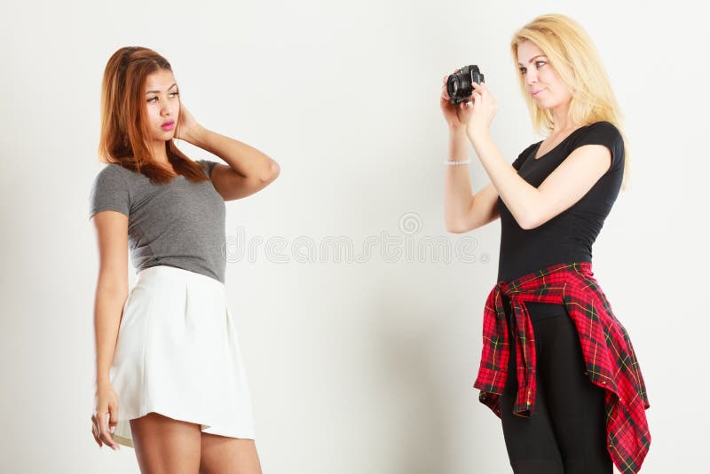 Blonde girl photographing mulatto woman royalty free stock image Blonde girl photographing mulatto woman royalty free stock image