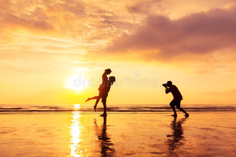 Photographer photographing a loving couple on the beach in summer, holidays vacation