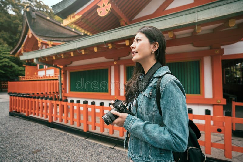 Photographer standing near red wooden temple royalty free stock photos