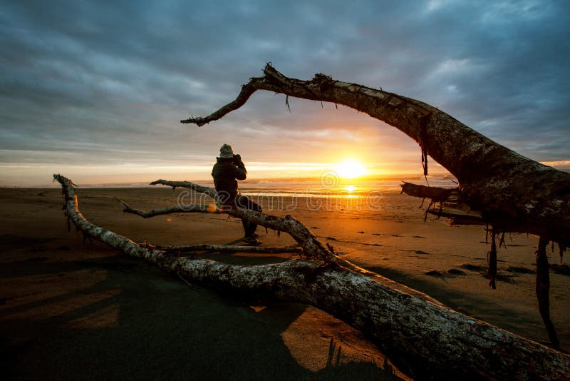 Photographer and sun set on black beach hokitika south island ne stock image Photographer and sun set on black beach hokitika south island ne stock image